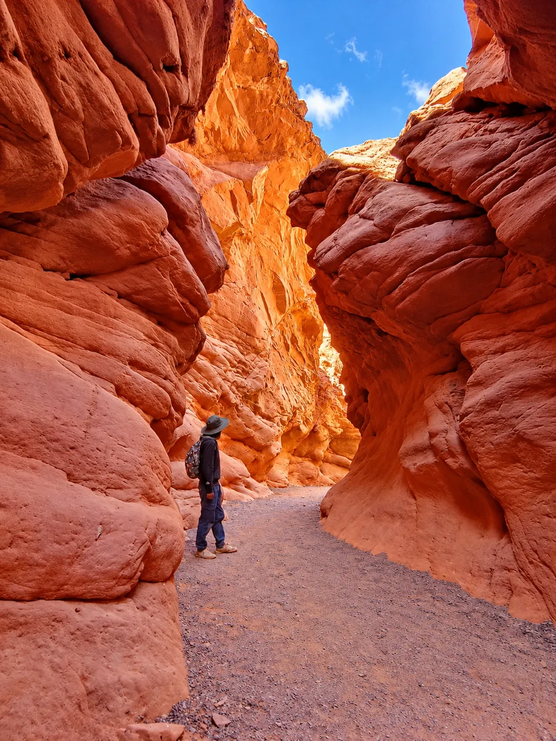 Caminante entre las paredes rojizas de la Quebrada de las Señoritas en Uquía, Jujuy